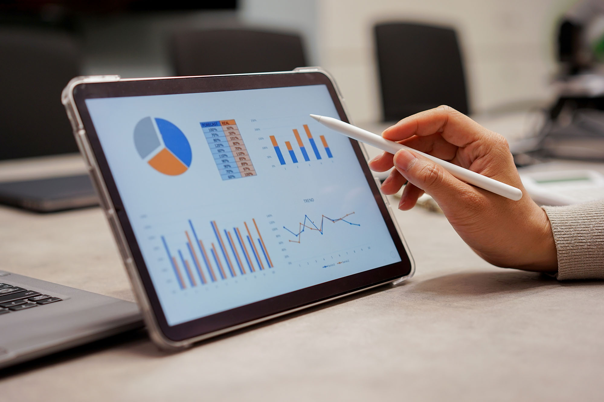 Hand mit Stift zeigt Info Grafik mit Diagrammen auf iPad